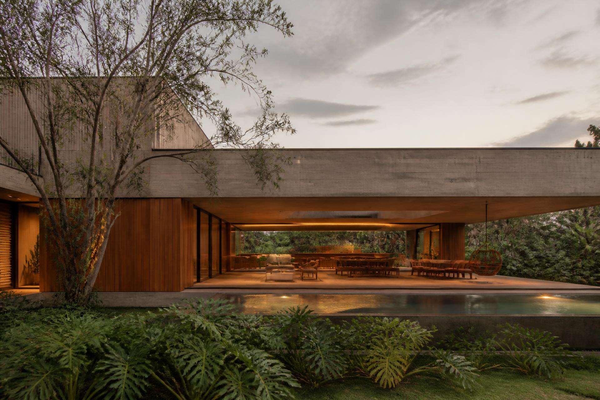 Casa Ipanema ao entardecer, concreto aparente e mata